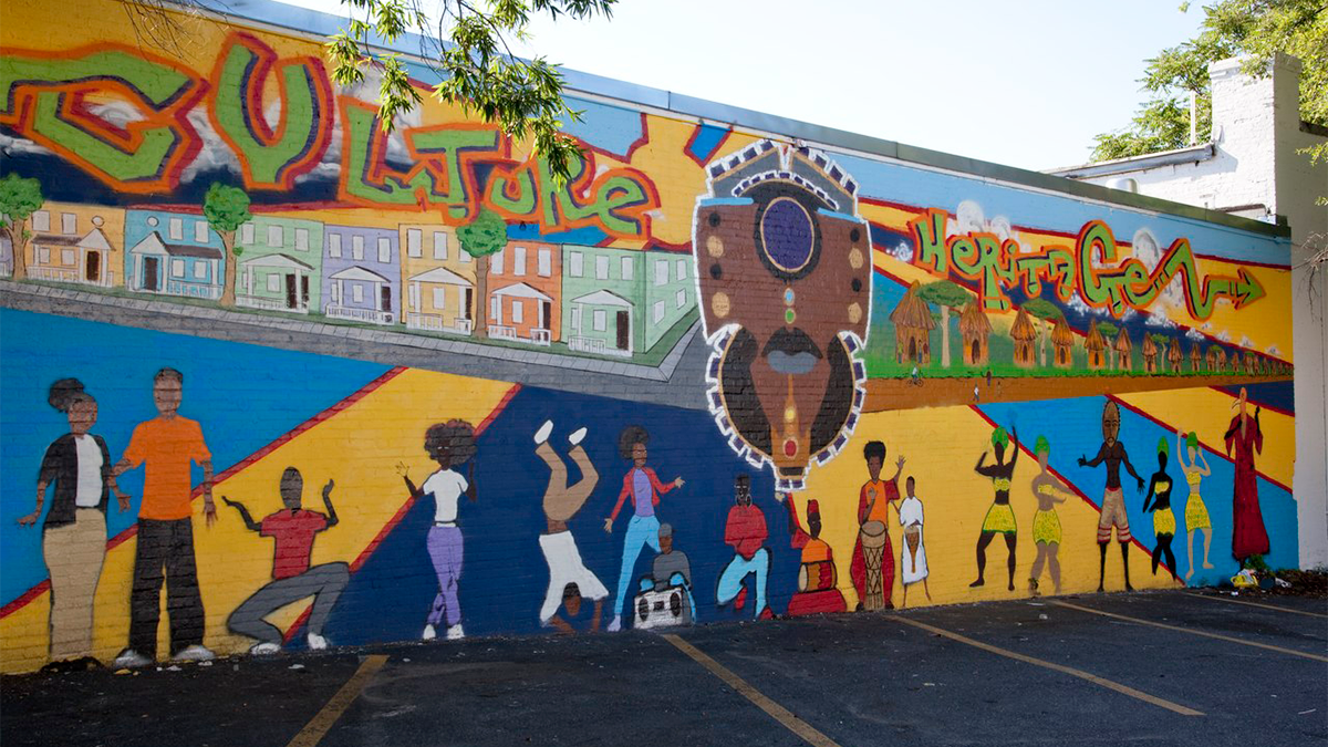 A colorful mural on a brick wall in a parking lot in the Anacostia neighborhood of D.C.