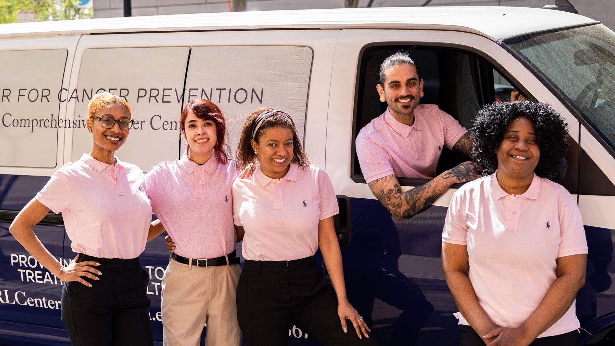 Five patient navigators pictured with the van for the Ralph Lauren Center